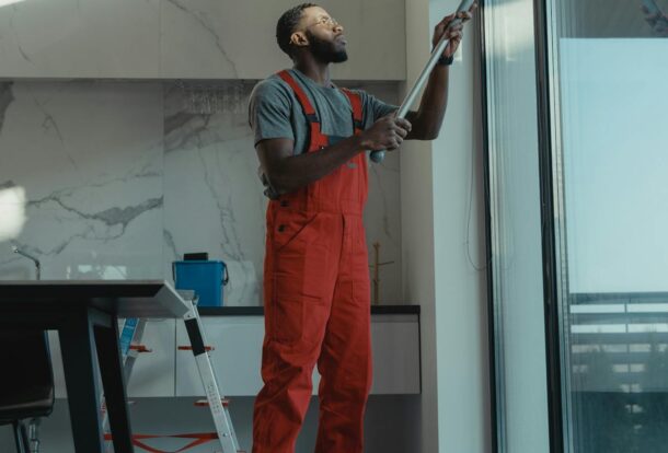 Professional using water-fed pole to clean a large interior window streak-free