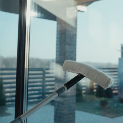 Water-fed pole brush head pressed against a clean glass window for purified water window cleaning