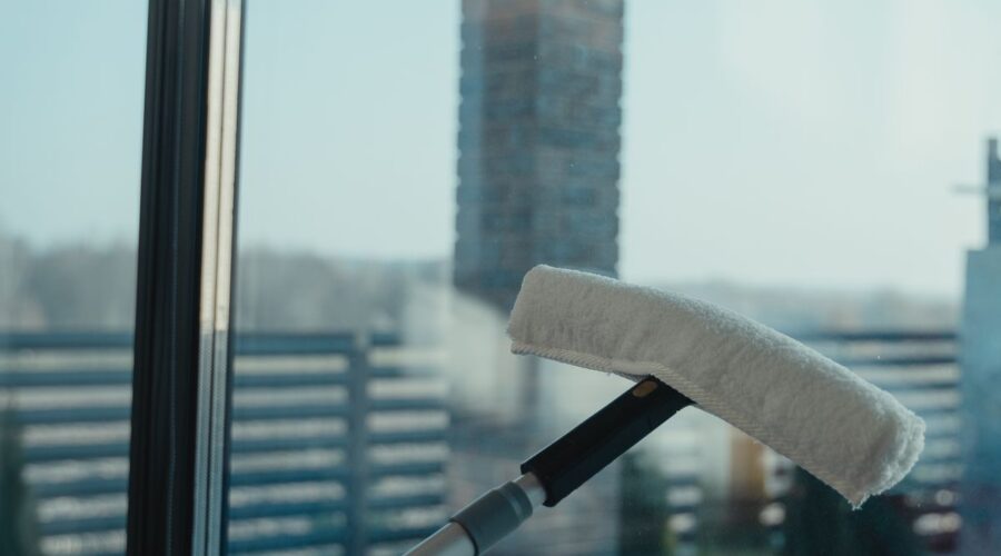 Water-fed pole brush head pressed against a clean glass window for purified water window cleaning